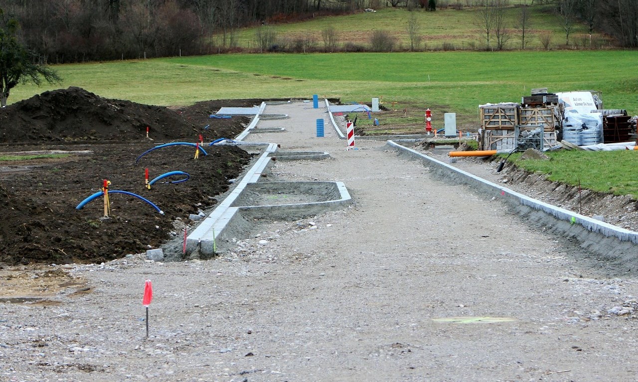 Start of a development project, mounds of dirt, gravel on a plot of land.