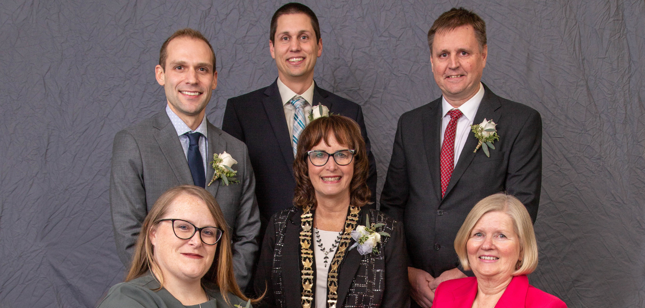 Picture of the council members and mayor dressed nicely and wearing boutonniere